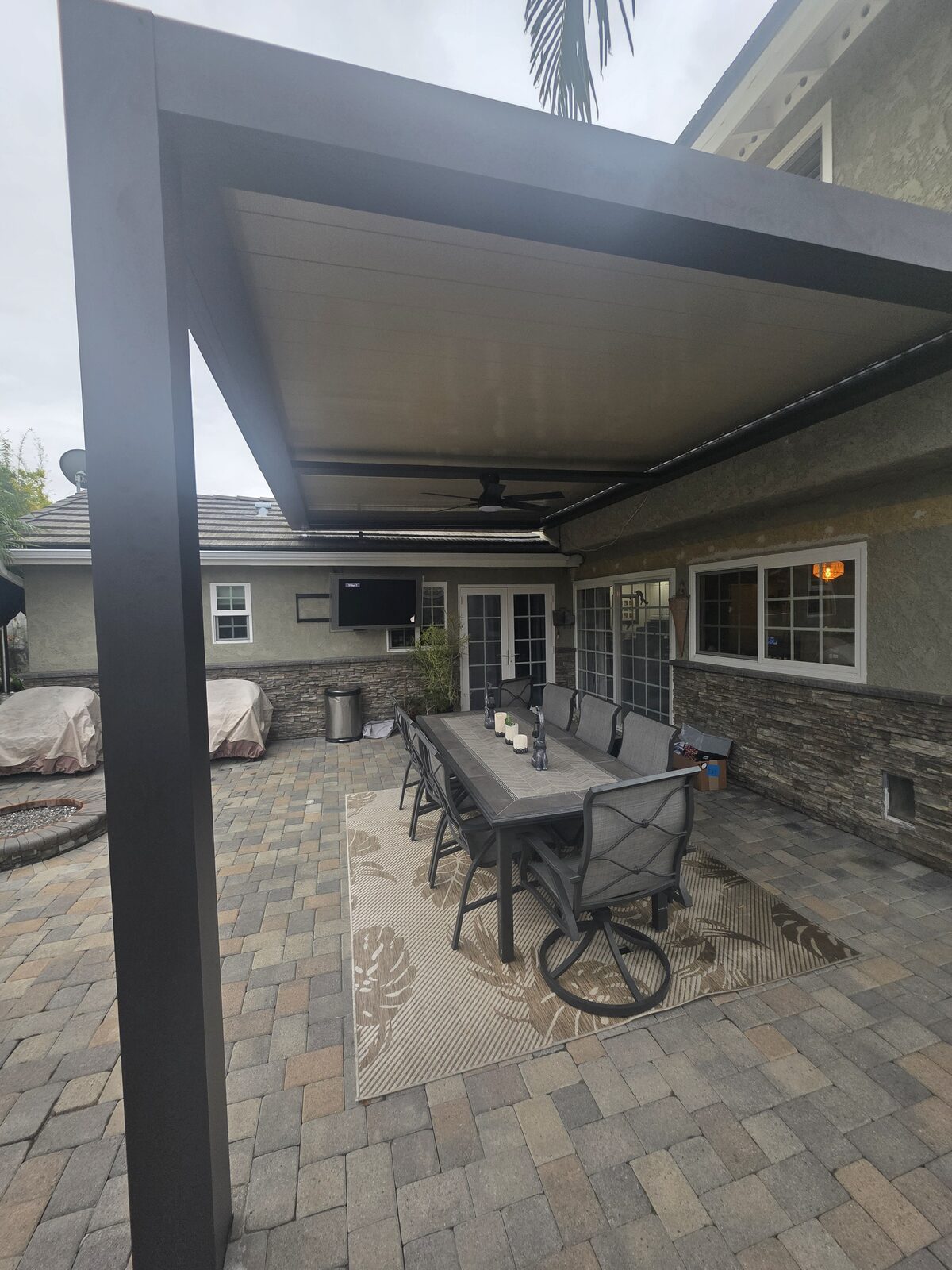 Front yard with block retaining wall, travertine cap, stacked-stone pilasters, artificial turf and stamped concrete