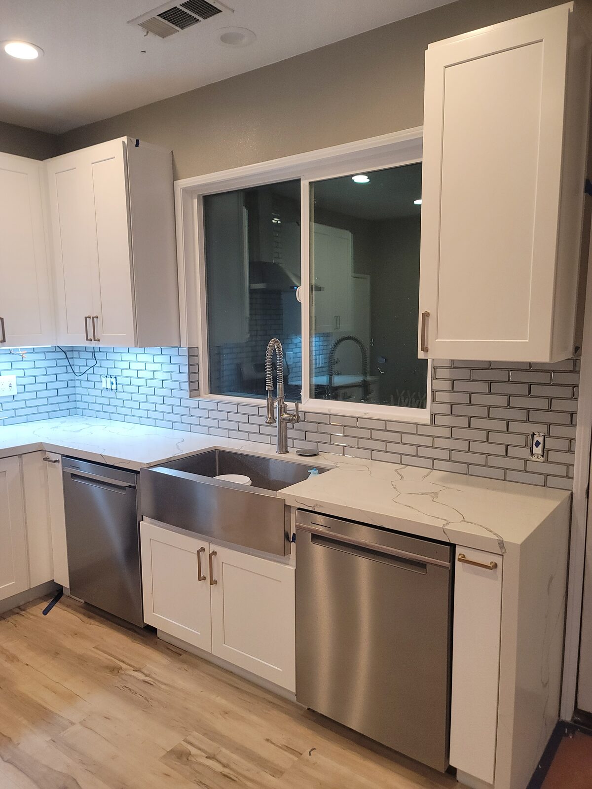 South Orange County kitchen with stainless farmhouse sink, subway tile backsplash and Calacatta-pattern quartz counters